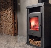 Családi ház kandallókályhával és kőmintás padlón lévő fával.