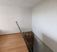 Családi ház: létra, fa mintázatú padló, tárolt fa, fehér falak.