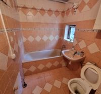 Fürdőszoba csempével és burkolattal, kád, mosdó és WC családi házban.