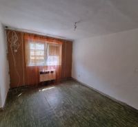 Szoba egy családi házban padlóval és függönyös ablakokkal.