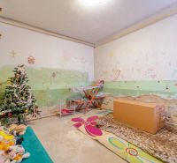 Gyerekszoba díszített karácsonyfával, rajzokkal a falakon és plüss játékokkal a családi házban.