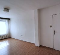 Tágas szoba egy családi házban, fa dekorációjú padlóval és nagy ablakkal.