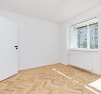 Szoba egy háromszobás lakásban, fa dekoros padlóval és nagy ablakkal.