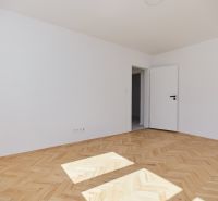 Világos szoba fehér falakkal és fa dekorációjú padlóval, 3 szobás lakás.