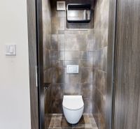 Sötét csempékkel ellátott WC a 4 szobás lakásban, a helyiség elegáns kialakítása.