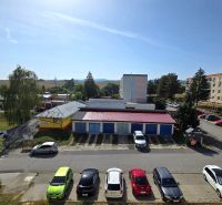 Kilátás a Besztercebányai Német útra épületekkel és parkolóval.