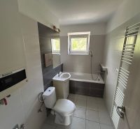 Fürdőszoba egy háromszobás lakásban káddal, mosdóval, WC-vel és létrás radiátorral.
