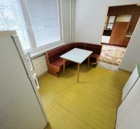 Konyha háromszobás lakásban sarokpadkával és asztallal.