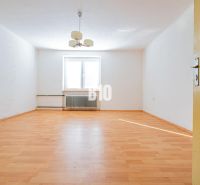 Családi ház belső tere fa mintázatú padlóval és fehér falakkal.