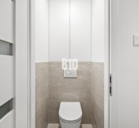 Fehér ajtós és csempés WC egy háromszobás lakásban.