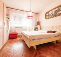 Hálószoba családi házban, fa dekorációjú padlóval és vintage kiegészítőkkel.