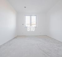 Egy üres szoba egy családi házban betonpadlóval és műanyag ablakkal.