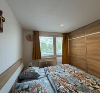 Hálószoba nagy szekrénnyel, franciaággyal és ablakkal egy háromszobás lakásban.