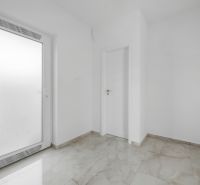 Fehér előszoba a családi házban csempével és ajtókkal.