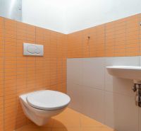 Fürdőszoba a nyaraló apartmanban narancssárga csempékkel és fali WC-vel.