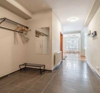 A rekreációs apartman folyosója járólappal, tükörrel és fogasfallal.