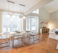 Rekreációs apartman étkezőasztallal, kényelmes kanapékkal és fa dekorációjú padlóval.