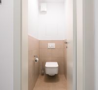 Két szobás lakás csempézett fürdőszobája, semleges színpaletta.
