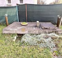 Kerti elem családi ház mellett Szenicén, fa dekorációval és növényzettel.