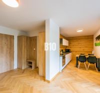Konyha és étkező egy nyaraló apartmanban fa dekor padlóval.