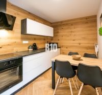 Konyha a Nyaraló apartmanban fa dekor padlóval és stílusos bútorokkal.
