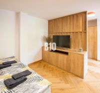 Rekreációs apartman ággyal, TV-vel, fa dekoros padlóval és fa bútorokkal.