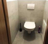 Fürdőszoba egy kétszobás lakásban csempével és fali WC-vel.