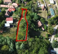 Légi felvétel a Kolačnában található kertekről, amelyeket házak és zöldterületek vesznek körül.