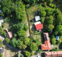 Légi felvétel Kolačná kertjeiről és házairól, sűrű zöld növényzettel körülvéve.