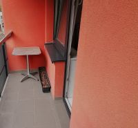Erkély piros falakkal egy kétszobás lakásban a Nábrežná utcában, Vrútkyban.