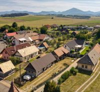 Žabokreky: Családi házak panorámája vidéki jelleggel és háttérben dombokkal.