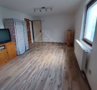 Szoba családi házban televízióval és fa dekorációjú padlóval.
