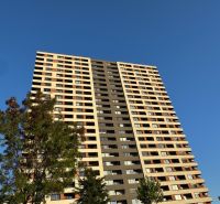 Magas épület a pozsonyi Bosák utcában, Pozsony-Petržalka városrészben, zöldövezet veszi körül.