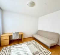 Szoba világos kanapéval, íróasztallal és fa dekorációjú padlóval egy 4 szobás lakásban.