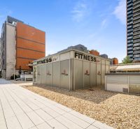 Pozsony - Nivy, Trenčianska: Fitneszközpont, amelyet modern épületek és burkolt területek vesznek körül.