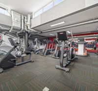 Fitnesz központ edzőfelszereléssel, tükrökkel és légtechnikával kereskedelmi helyiségekben.