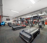 Fitneszközpont futópadokkal és edzőeszközökkel kereskedelmi helyiségekben.