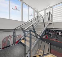 Kétszintes üzlethelyiség acéllépcsővel és fitneszberendezésekkel.