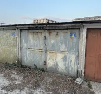 Elhagyatott garázsok Pozsony-Újvárosban, lehullott vakolattal és bádogajtókkal.