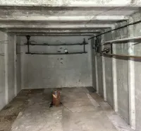 Üres beton garázs belső tér polcokkal és világítással.