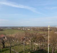 Kilátás a Banka melletti házikóból, amely zöld területeket és távoli mezőket kínál.