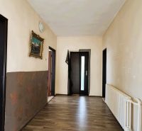 Egy családi ház folyosója fa dekorációs padlóval és egy képpel a falon.