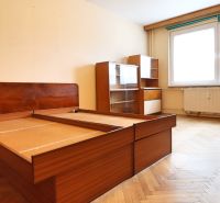Hálószoba fa dekorációval az ágyon és bútorokkal egy kétszobás lakásban.