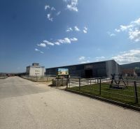 Ipari épület Hniezdnében, tiszta kék égbolttal és bevezető úttal.
