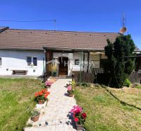 Családi ház Borsky Mikulášban kerttel és virágokkal a verandán lévő cserepekben.