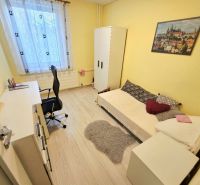 Sárga szoba egy ággyal, íróasztallal és fa dekorációjú padlóval egy 4 szobás lakásban.