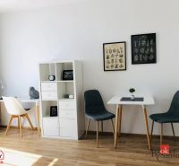 1 szobás lakás belső tere fa dekoros padlóval és stílusos székekkel.