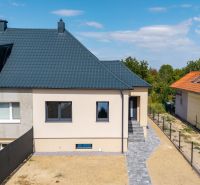 Családi ház a Nyitrai Trnavská utcában sötét tetővel és rendezett udvarral.