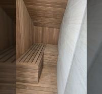 Szauna a villa belsejében fa burkolattal és padokkal.