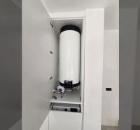 Boiler a szekrényben a villában, fehér fal, egyszerű belső tér.